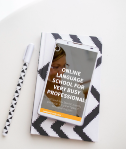 phone on top of white and black notebook and written on it online language school for busy professionals black notebook
