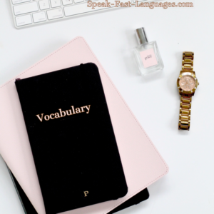black notebook on tope of a pink one with the word vocabulary